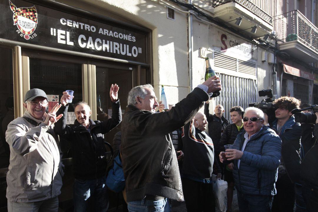  Un grupo de personas celebran haber sido agraciados con el número 26590 el Gordo de Navidad, que ha sido vendido, entre otros lugares, en el Centro Aragonés Cachirulo de Reus (Tarragona) 