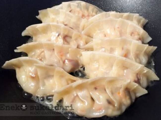 Añadimos agua al wok hasta cubrir un dedo las gyozas