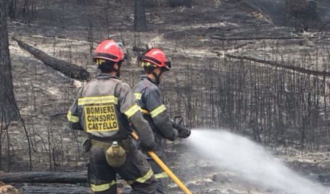 Bomberos refrescando zona incendiada