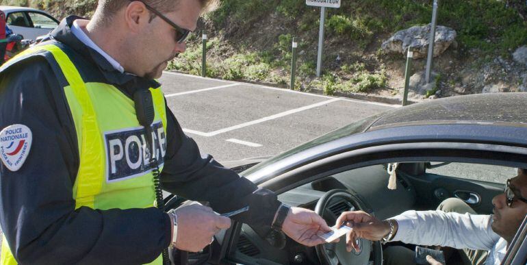 LE PERTHUS (FRANCIA).- Un agente de la Policía francesa comprueba la documentación de un conductor. EFE|