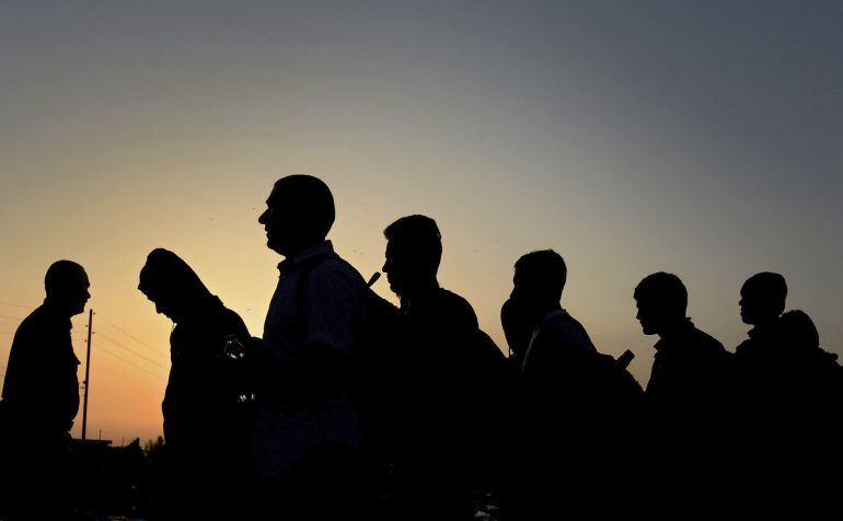 Refugiados esperan para entrar en un campamento de registro tras lograr cruzar a pie la frontera entre Macedonia y Grecia a la altura de Gevgelija 