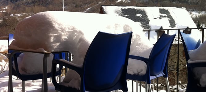 Mesa cubierta de nieve de la terraza de una cafetería en Arties (Lleida)