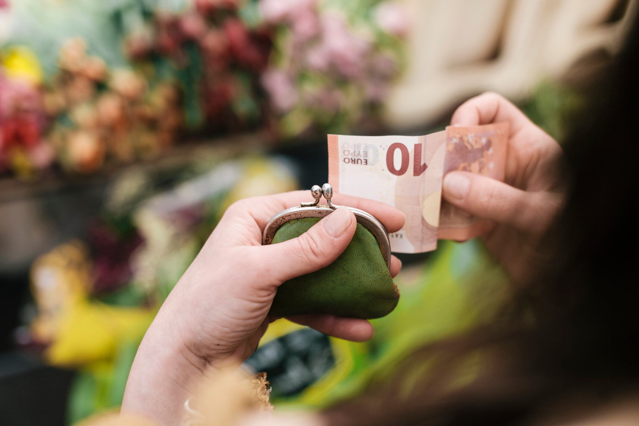 Una mujer saca un billete de 10 euros de su monedero