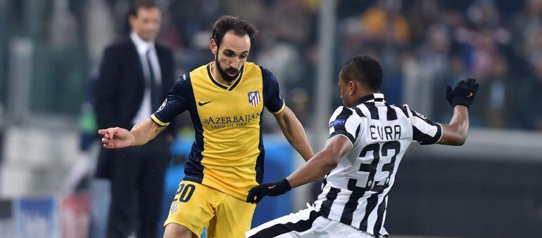 IRA05. TURÍN (ITALIA), 09/12/2014.- El jugador de la Juventus, Patrice Evra (dcha), pelea por el control del balón con el defensa del Atlético de Madrid, Juanfran Torres, durante el partido correspondiente al grupo A de la Liga de Campeones disputado en e