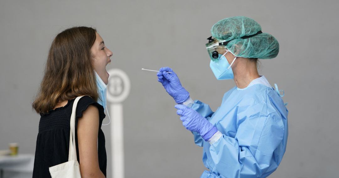 A medical worker administers a PCR test