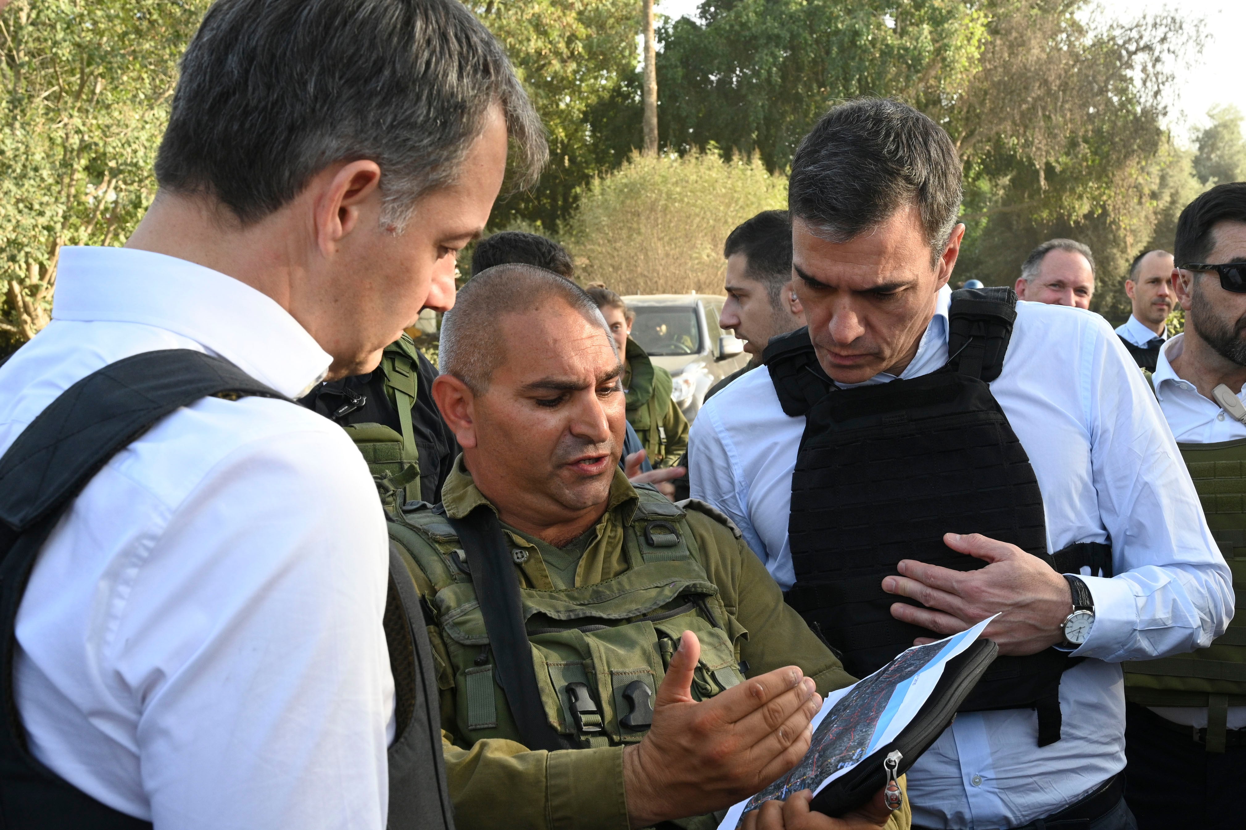 El presidente del Gobierno Pedro Sánchez (d) y el primer ministro belga, Alexander de Croo (i), escuchan a un mando militar israelí que les relata lo que ocurrió en el kibutz de Be&#039;eri el 7 de octubre durante su visita a Israel.