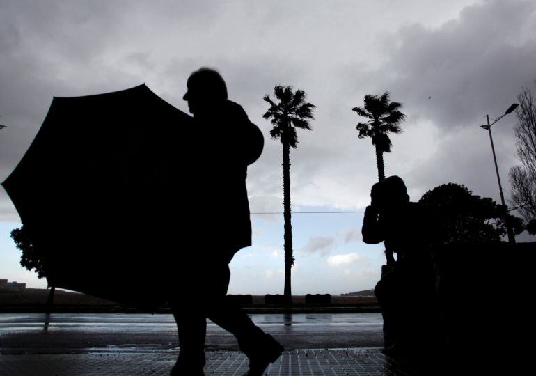 Dos personas caminando por el paseo marítimo de A Coruña durante el paso de una intensa borrasca llamada Hugo.