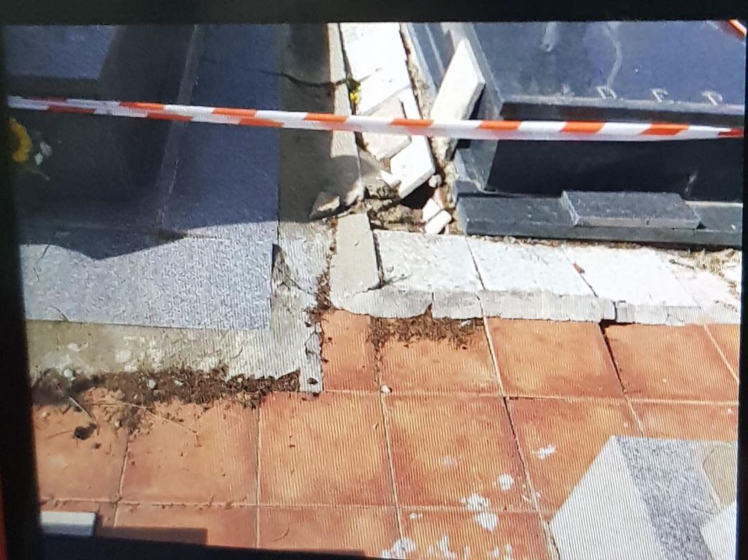 Imágen de una de las zonas del suelo del cementerio junto a dos sepulturas.