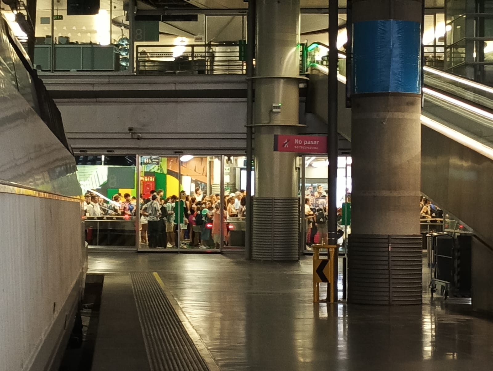 Pasajeros esperando en el acceso a los andenes de Atocha