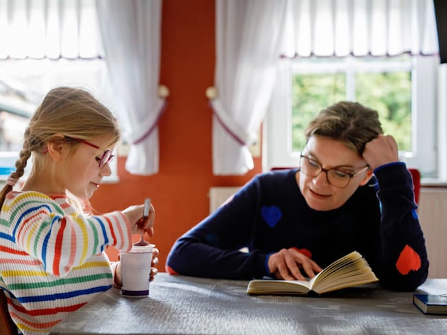 Mother reading a book for her little daughter. happy family time.