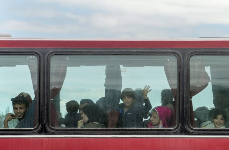 Un grupo de refugiados es trasladado en autobús tras ser desalojado del campamento de Idomeni