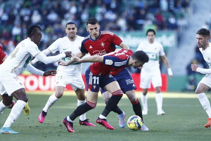 El jugador de Osasuna Kike Barja intenta controlar el balón entre Palacios y Carmona