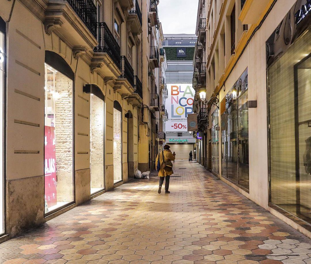 Una calle comercial de Valencia con todos sus establecimiento cerrados 