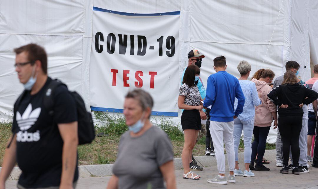 Varias personas esperan junto a una carpa en la que se hacen test Covid19.