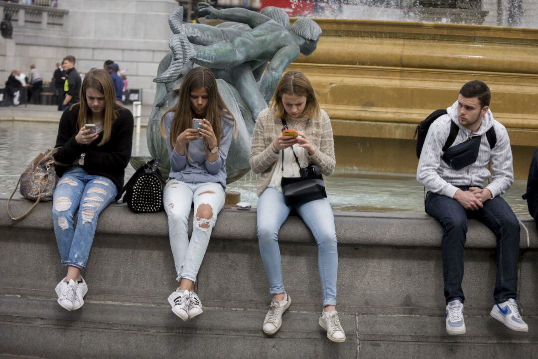 Adolescentes mirando sus teléfonos móviles