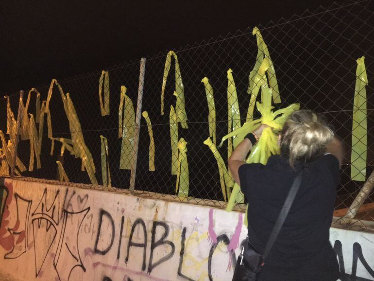 Una voluntaria quitando lazos amarillos