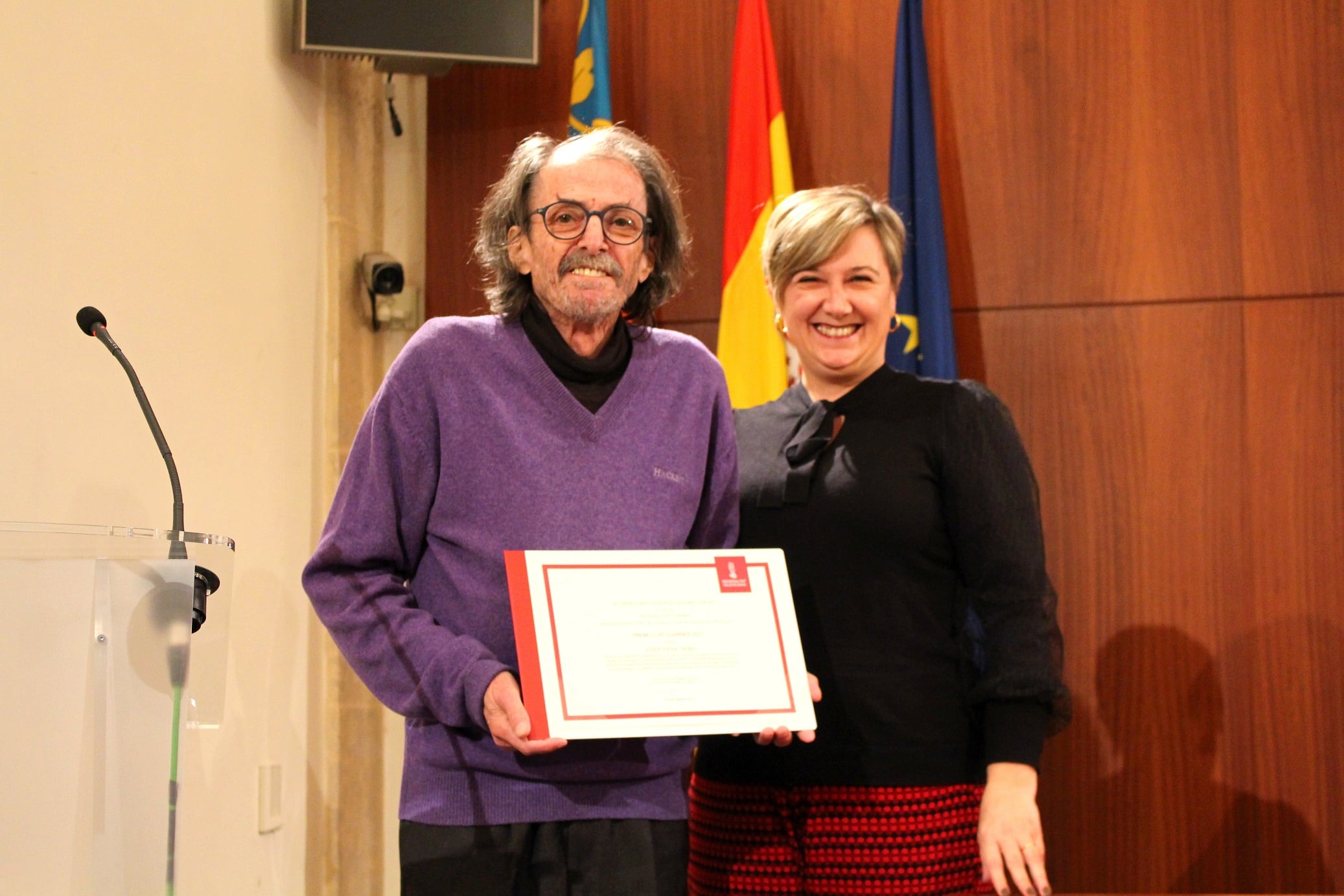 Josep Piera recogiendo el premio junto a la Consellera, Raquel Tamarit.