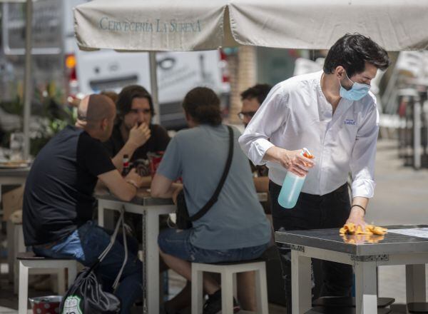 Un camarero limpia una mesa de la terraza de un bar durante el primer día de inicio de la Fase 3 de la desescalada en Sevilla.