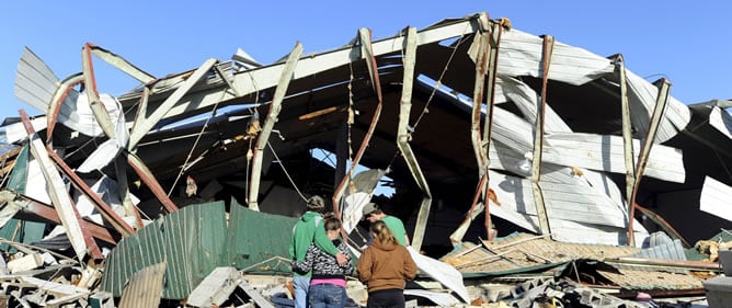 Unos estudiantes se abrazan ante los restos de su escuela después de que un tornado azotara la pequeña localidad estadounidense de Tushka