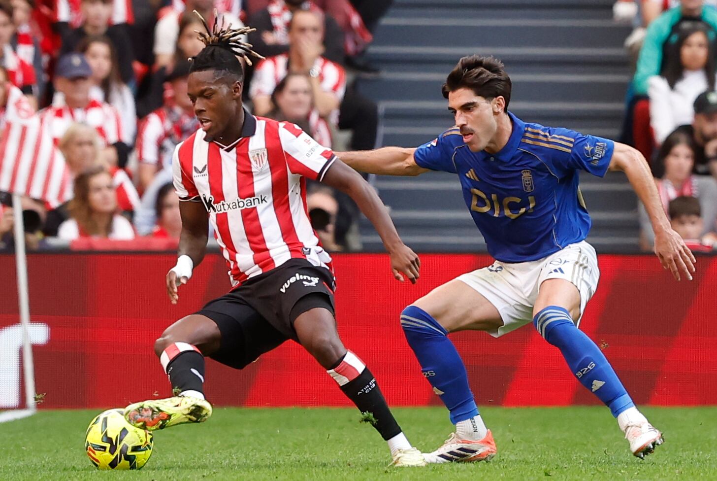 El delantero del Athletic Club Nico Williams ante el defensa del Real Oviedo Ignacio Vidal (d), durante el partido de la jornada 12 de Liga disputado este domingo en el estadio de San Mamés
