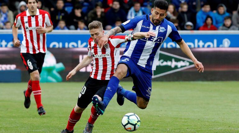El delantero del Athletic de Bilbao, Íker Muniain (i), disputa el balón ante el defensa chileno del Deportivo Alavés, Guillermo Maripán (d), durante el partido correspondiente a la jornada 37 de LaLiga Santander disputado hoy en el Estadio de Mendizorroza
