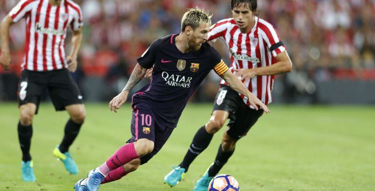  El delantero argentino del F. C. Barcelona, Leo Messi (c), conduce el balón ante el centrocampista del Athletic de Bilbao, Ander Iturraspe, durante el encuentro correspondiente a la segunda jornada de primera división, que disputan esta noche en el estad