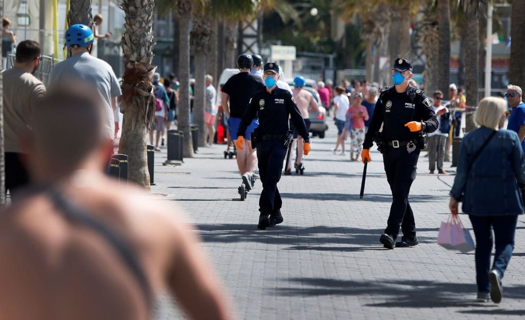 La policía local de Benidorm patrulla en el paseo de la playa de Levante entre multitud de turistas