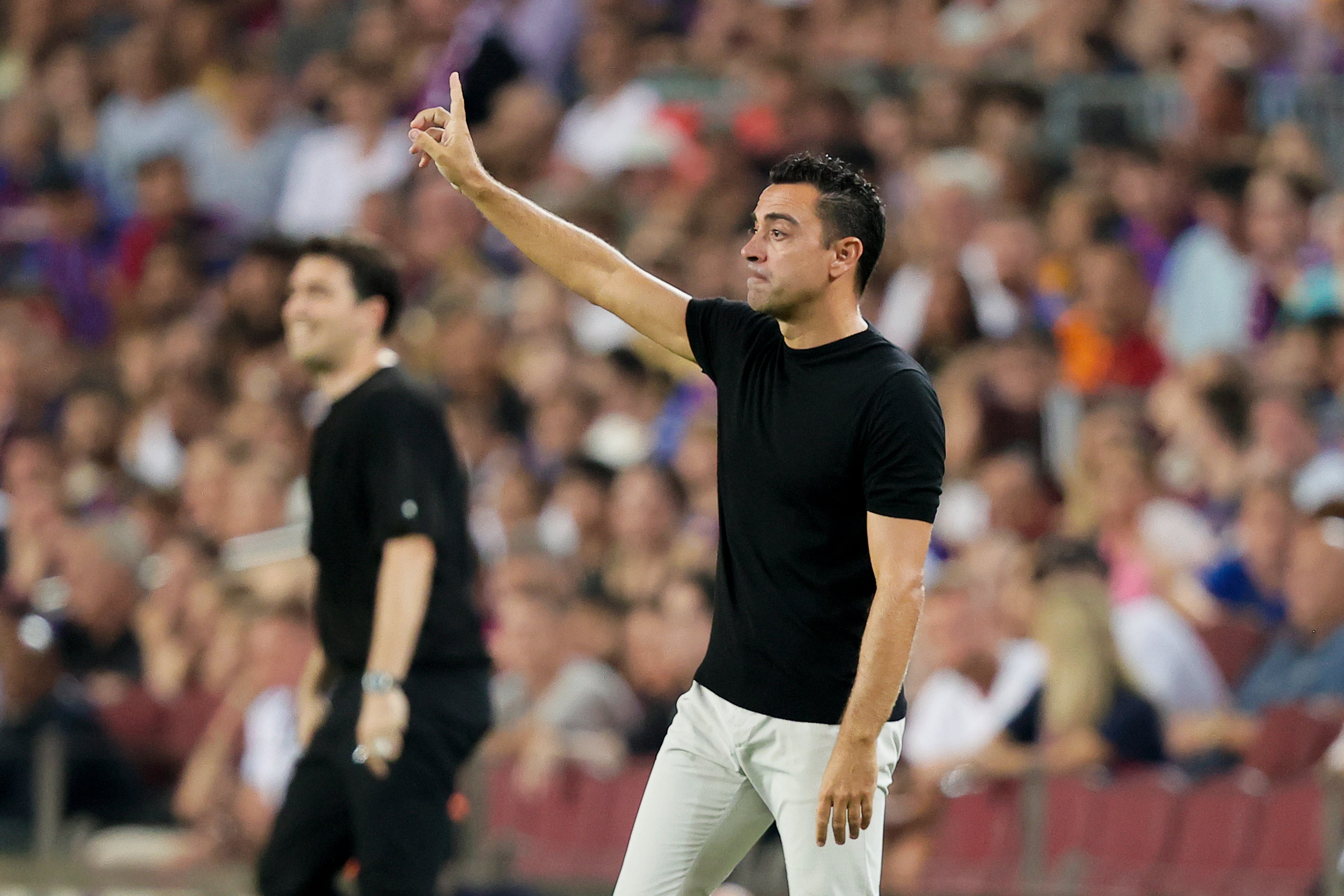 Xavi Hernández levanta la mano durante el partido del FC Barcelona en el Camp Nou.