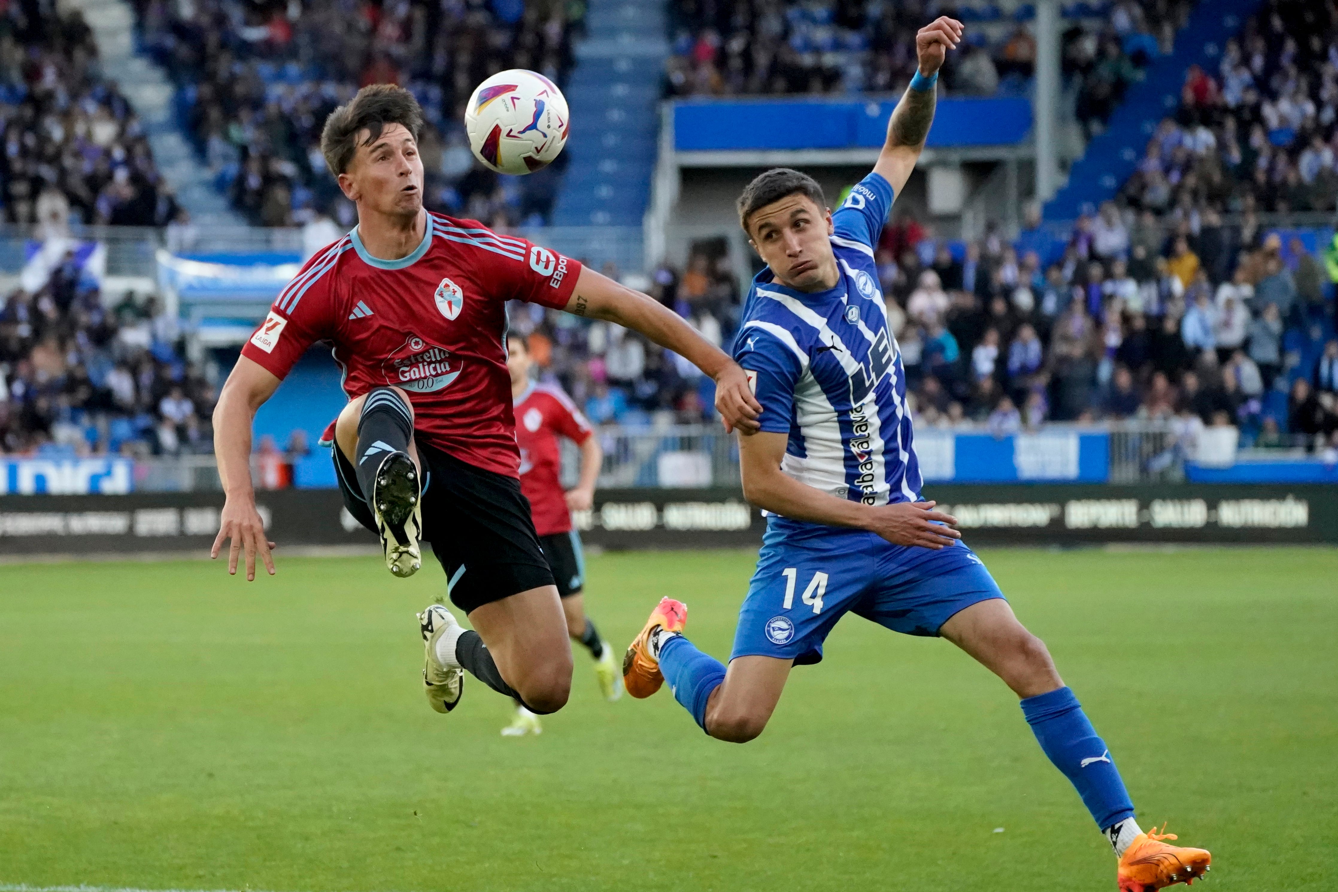 El jugador del Celta Hugo Álvarez (i) trata de controlar un balón ante Nahuel Tenaglia, del Alavés. EFE/L. Rico