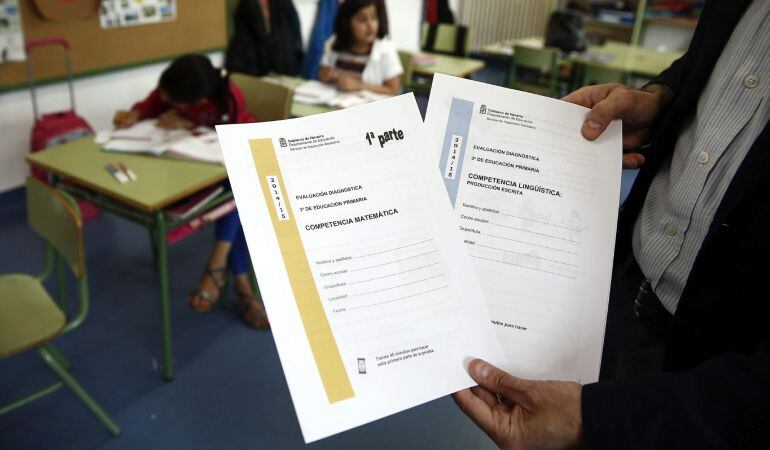 Un profesor muestra los cuestionarios que deben rellenar los alumnos, en la nueva evaluación externa de tercero de Primaria fijada por la Lomce