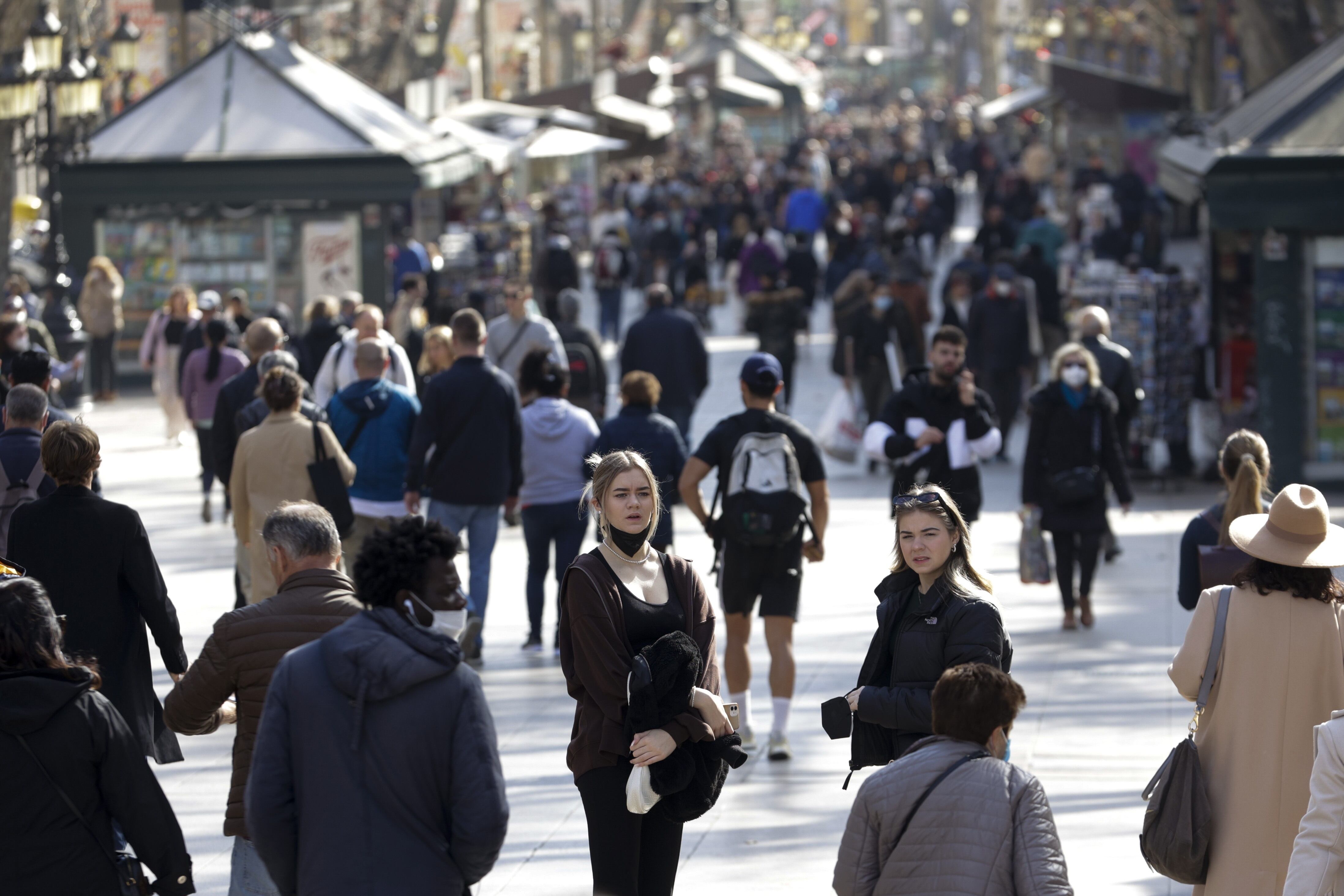 Varias personas caminan por Barcelona sin mascarilla