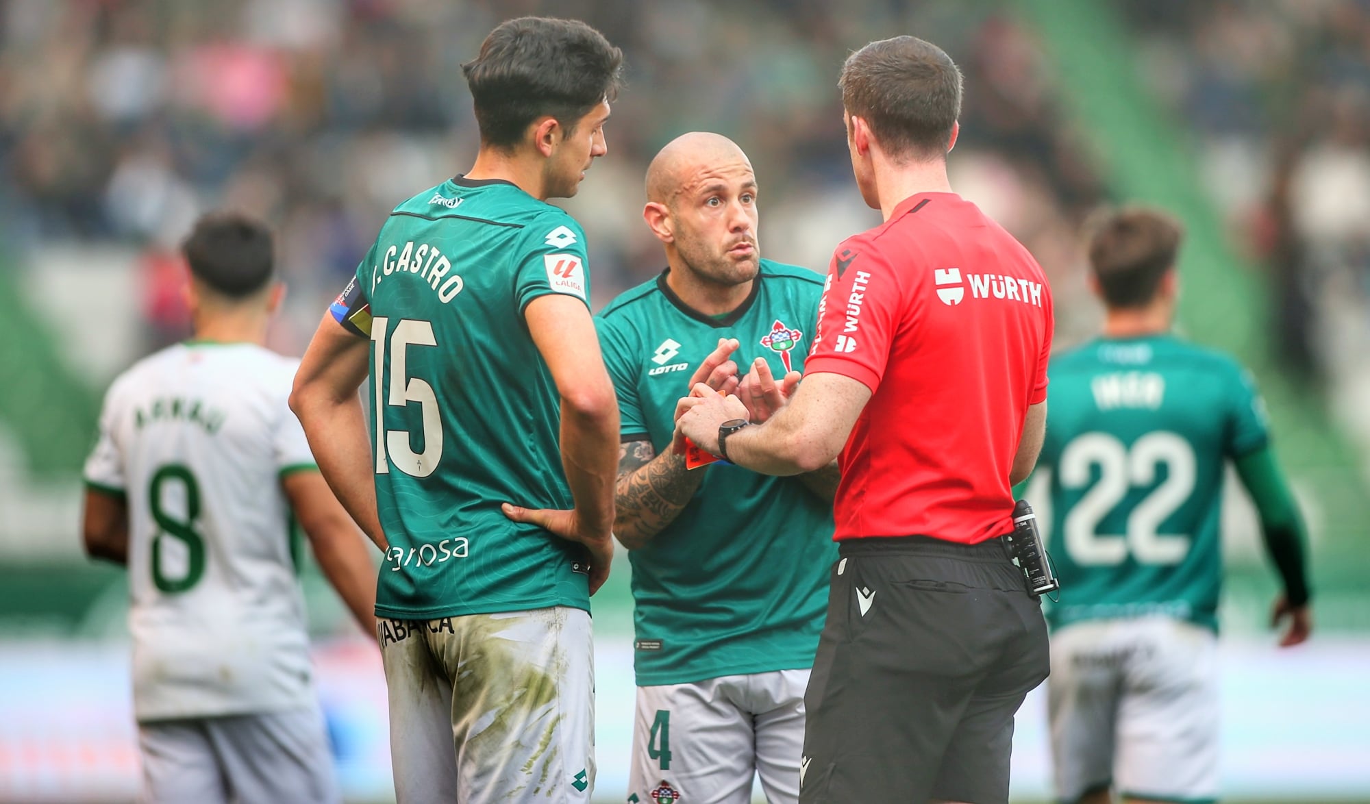 Jon García charla con el colegiado ante David Castro durante el Racing-Elche en A Malata (foto: Mero Barral / Cadena SER)