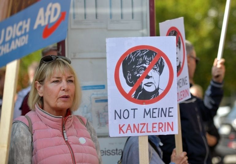 Supporters of the right-wing Alternative for Germany (AfD) political party demonstrate against the German Chancellor and Christian Democrat (CDU) Angela Merkel at a CDU election campaign stop on September 22, 2017 in Heppenheim, Germany. Germans will go t