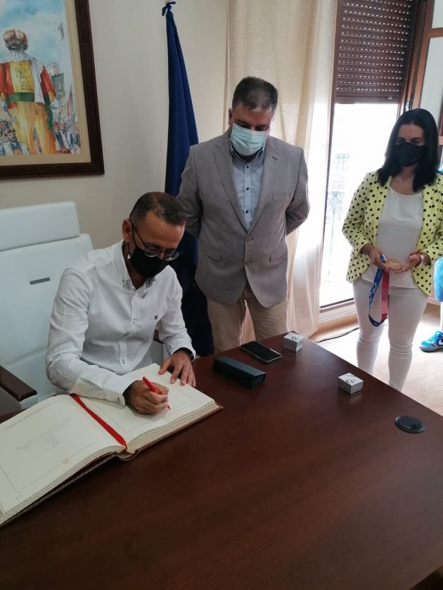 Samuel López firmando en el libro de honor