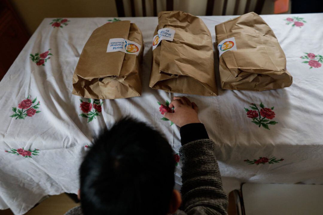 Archivo - Un niño durante la comida en su casa momentos antes de abrir el menú de la ONG del chef José Andrés, que reparte a las familias más necesitadas durante el estado de alarma provocado por el coronavirus (archivo).