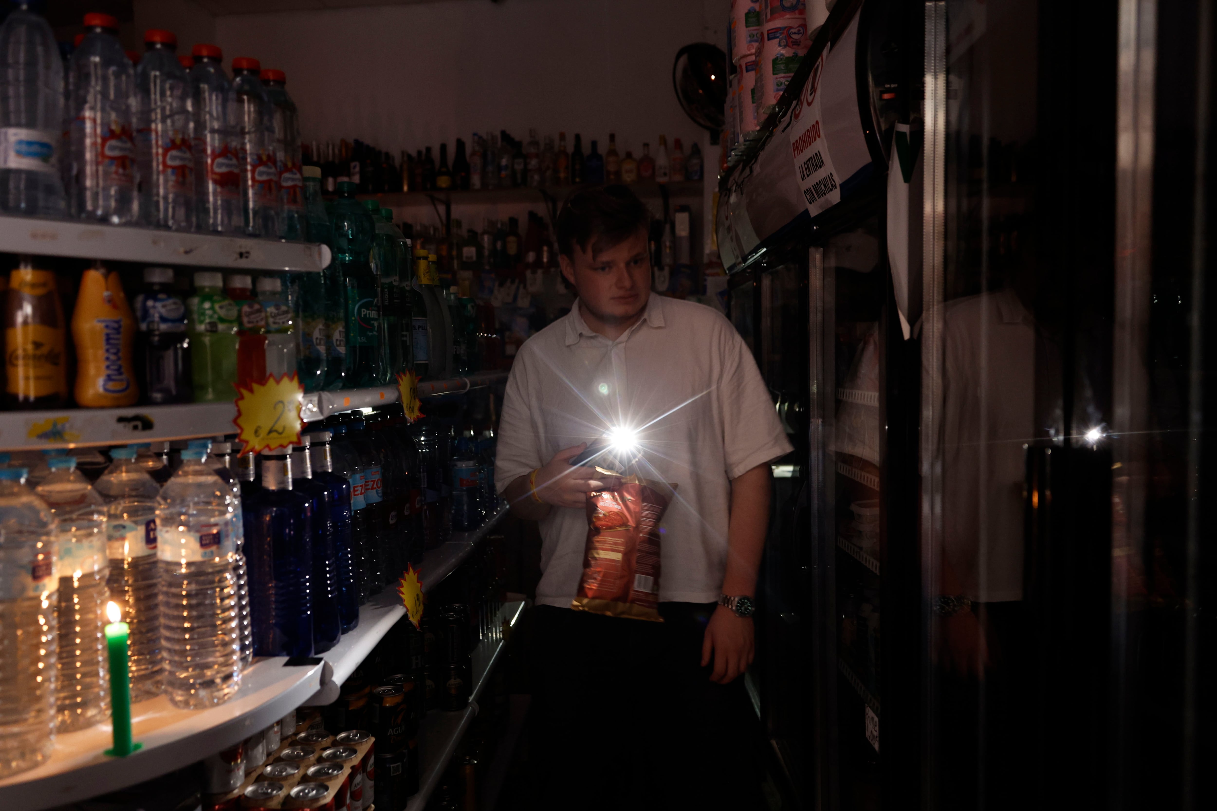 Valencia- 28/04/2025.- Una persona utiliza su teléfono móvil como linterna en un ultramarinos en Valencia, este lunes, con motivo del apagón de suministro eléctrico. El apagón eléctrico generalizado ha obligado a los bomberos de la provincia de Valencia a realizar ya más de ochenta servicios por rescates en ascensores, según fuentes de este cuerpo de seguridad.