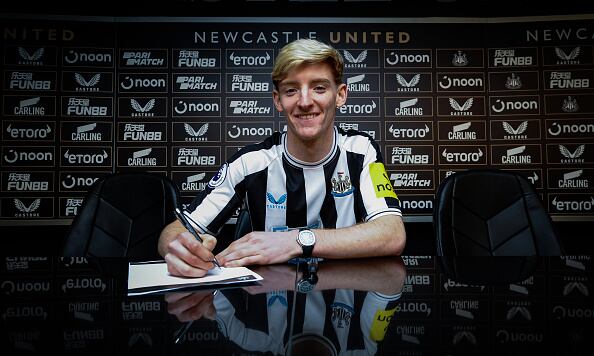 Anthony Gordon posa firmando su contrato con el Newcastle United