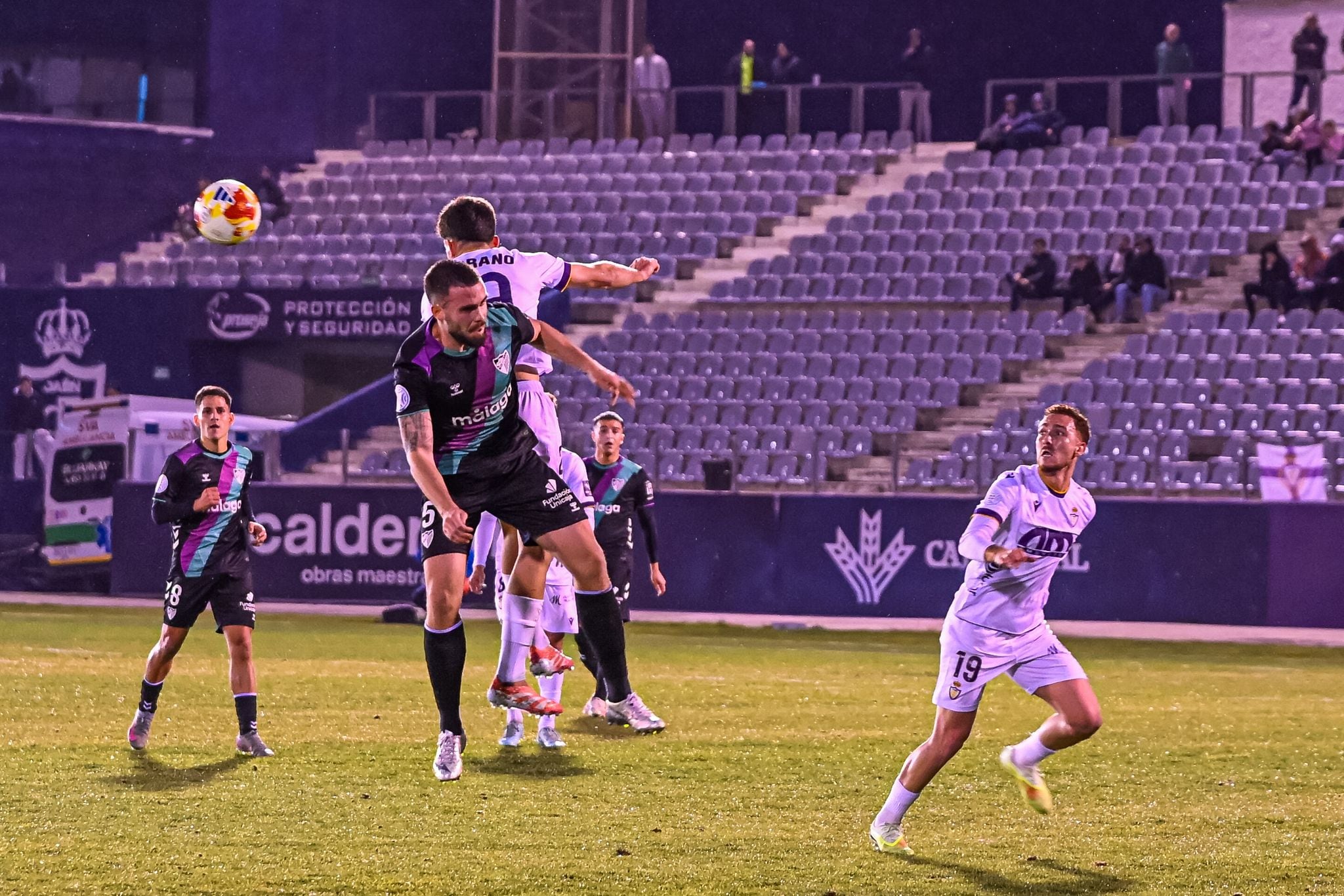 Futbolistas del Real Jaén y del Atlético Malagueño se disputan un balón durante el partido.