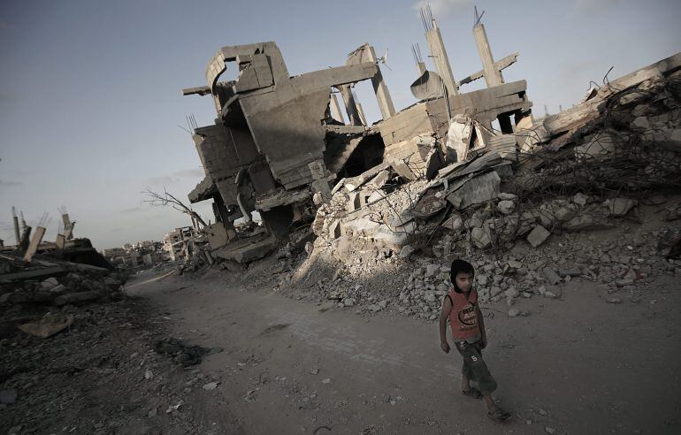 ABS113. AL SHEJAEIYA NEIGHBOURHOOD (FRANJA DE GAZA), 01/07/2015.- Un niño palestino es visto junto a casas destruidas durante el conflicto Israel-Gaza de 2014 hoy, miércoles 1 de julio de 2015, a pocos días de cumplirse el primer aniversario, en el vecind