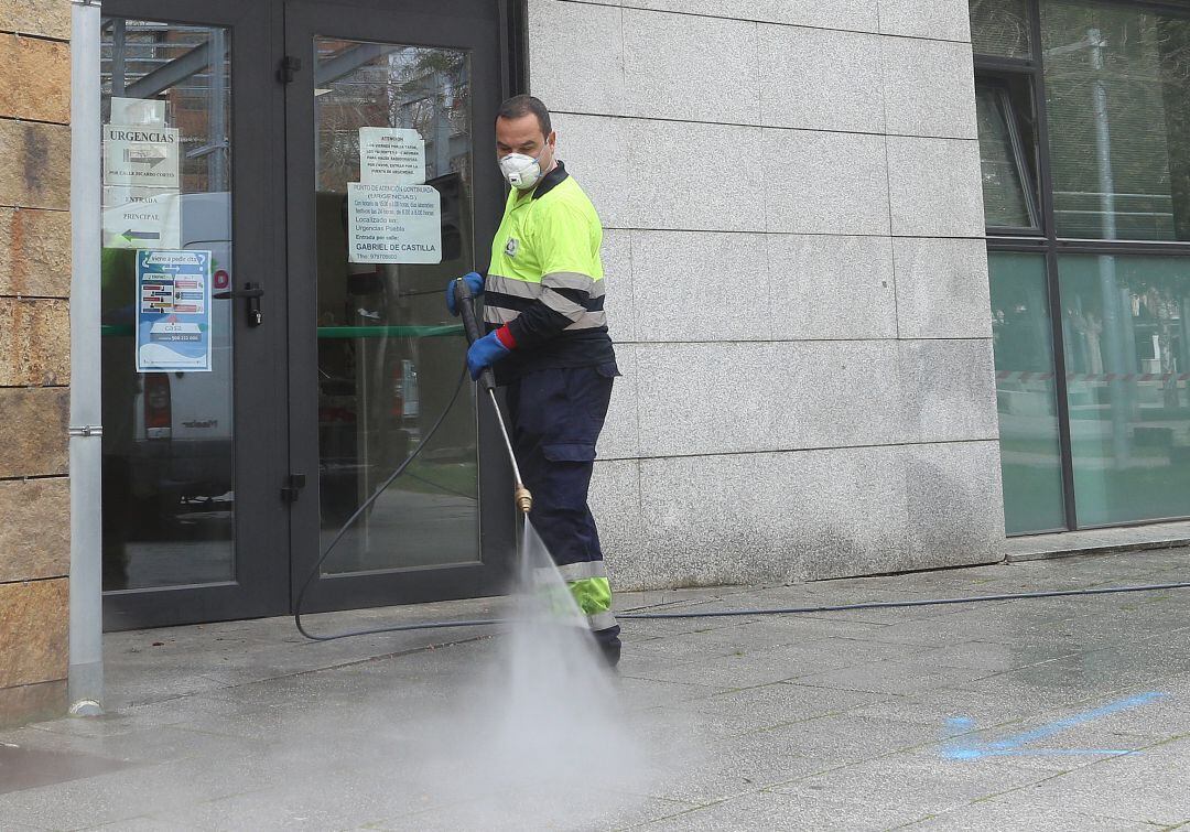 Un operario de Urbaser desinfecta en el exterior del centro de Salud de la Puebla en Palencia