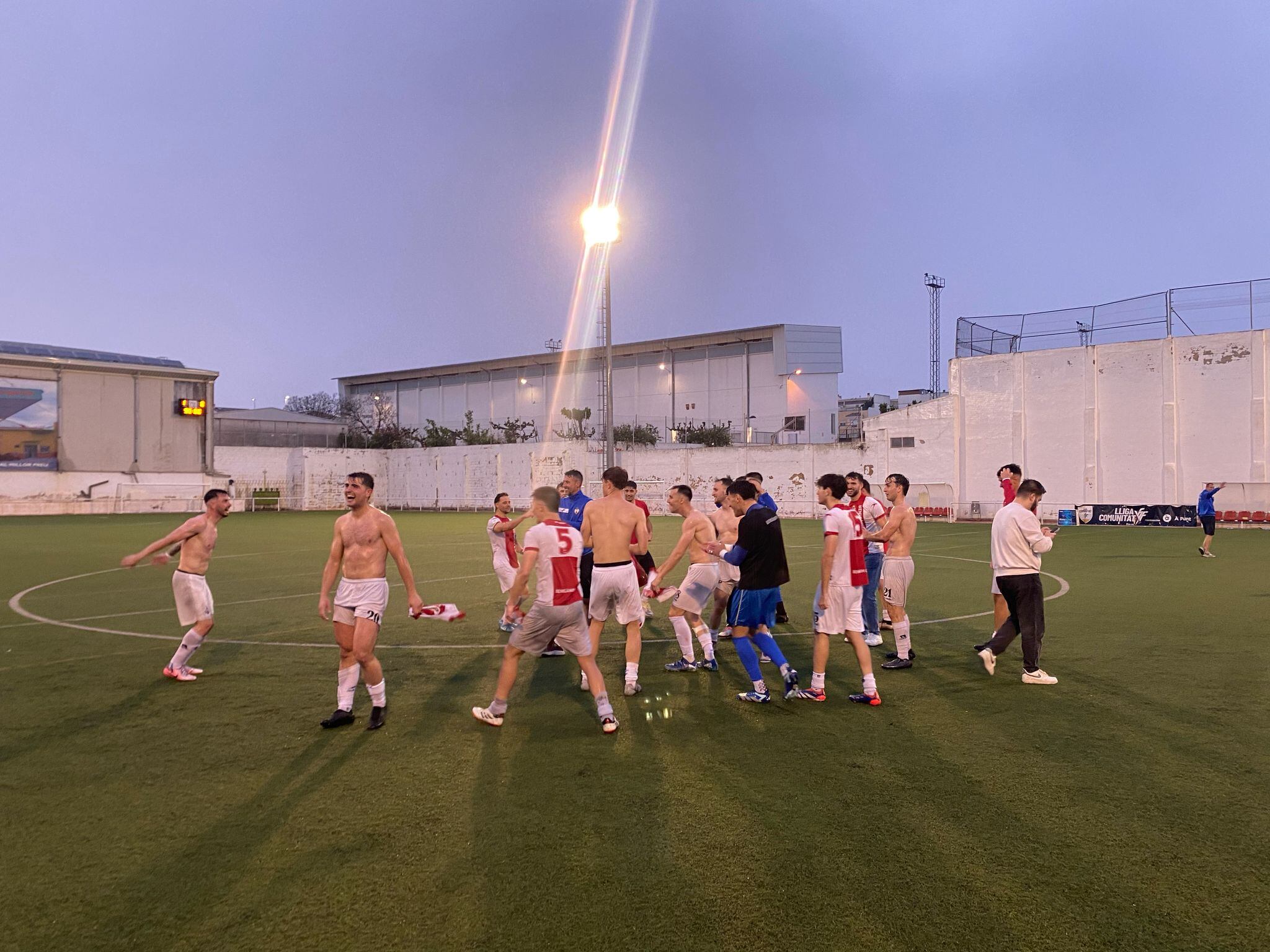 Los jugadores del Benigànim celebran sobre el césped la clasificación para el play-off tras una victoria sufrida ante el Dénia