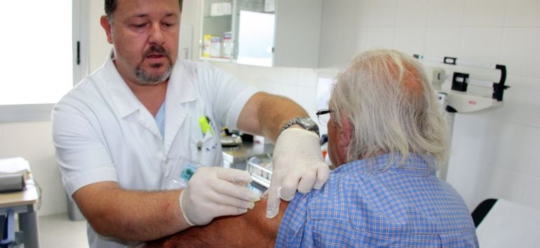 Un metge vacunant un pacient contra la grip.