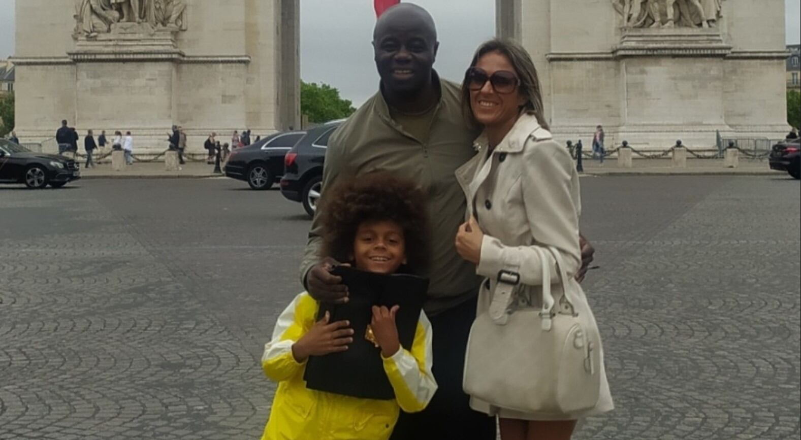 Una familia feliz posando junto al Arco del Triunfo en París.