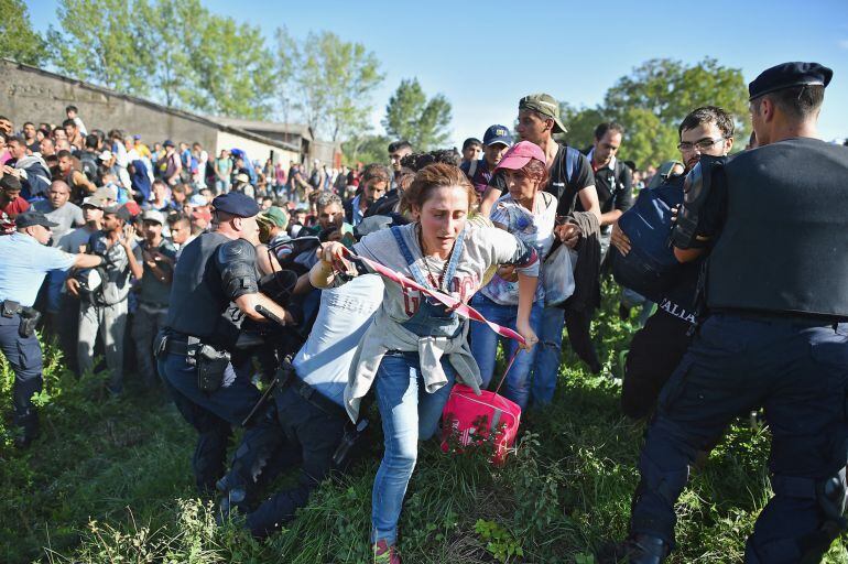 TOVARNIK, CROATIA - SEPTEMBER 17: Migrants force their way through police lines at Tovarnik station to board a train bound for Zagreb on September 17, 2015 in Tovarnik, Croatia. Migrants are now diverting to Croatia from Serbia after Hungary closed its bo