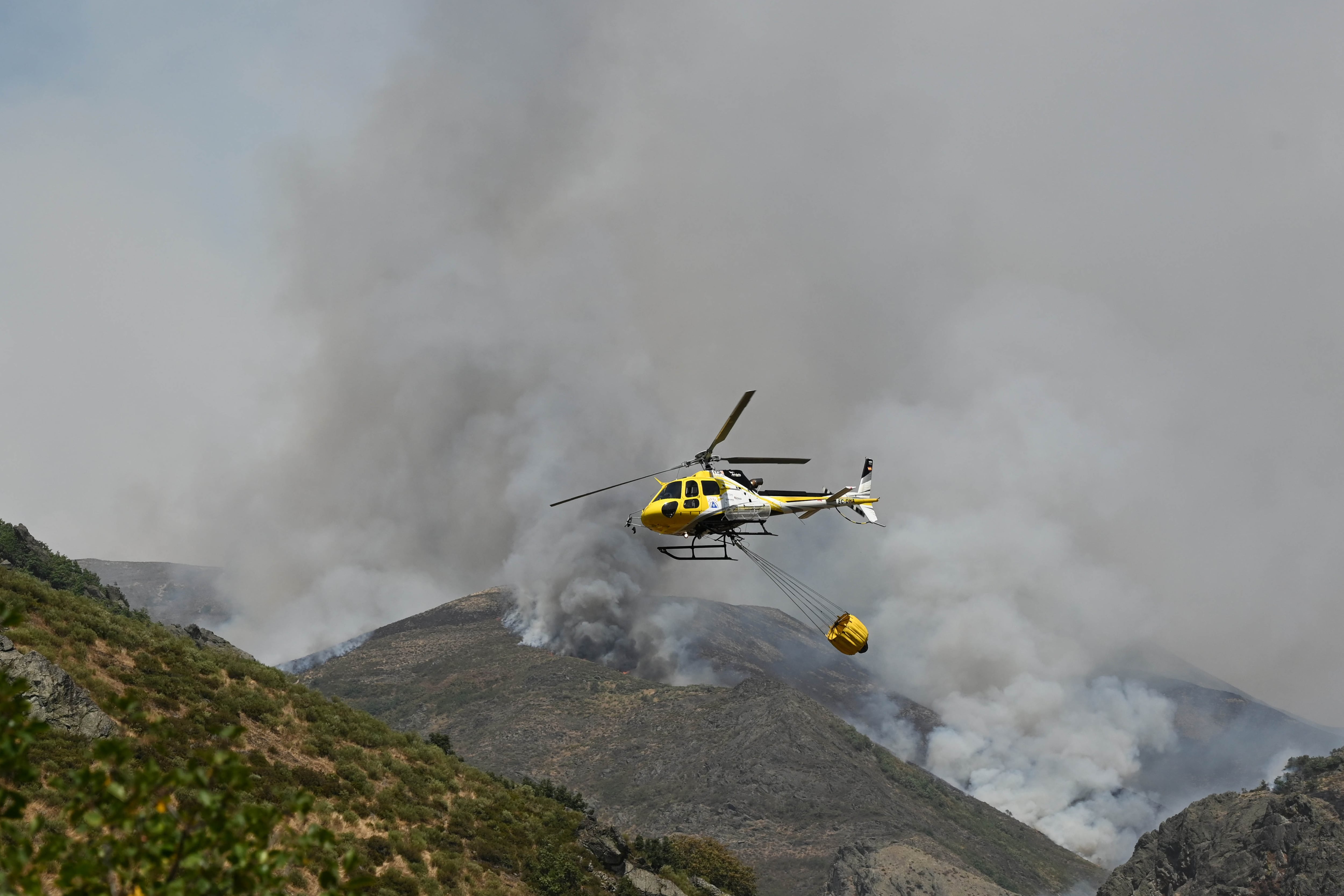 BARNIEDO (LEÓN), 16/08/2025.- Un helicóptero trabaja en las labores de extinción del incendio de Barniedo (León), que afecta a los Picos de Europa. Por primera vez en España, tres comunidades autónomas -Castilla y León, Asturias y Cantabria- han utilizado de forma coordinada el sistema de comunicación masiva de una emergencia a través de los teléfonos móviles Es-Alert para pedir a los ciudadanos cercanos a los Picos de Europa que abandonen cualquier actividad en la montaña. EFE/J.Casares
