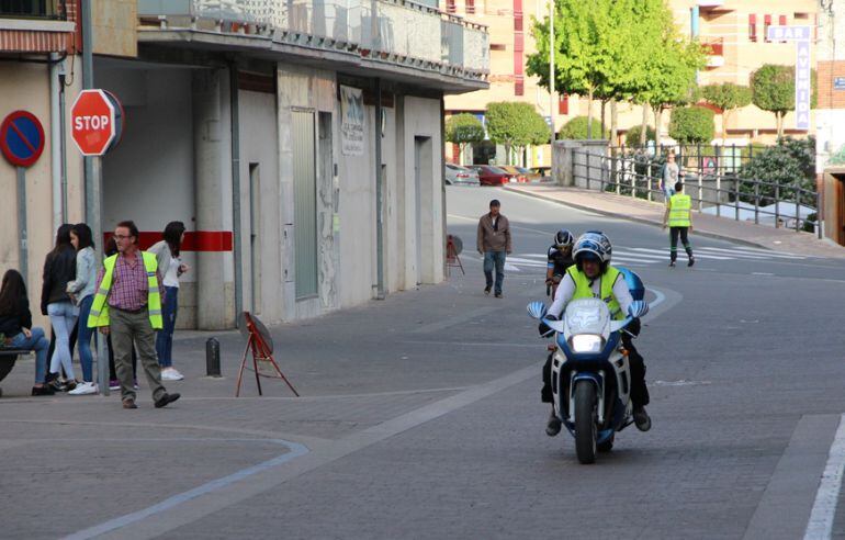 Una moto y dos voluntarios a pie de calle controlan el recorrido y guían aun ciclista que participó el pasado año en la Cronoescalada.