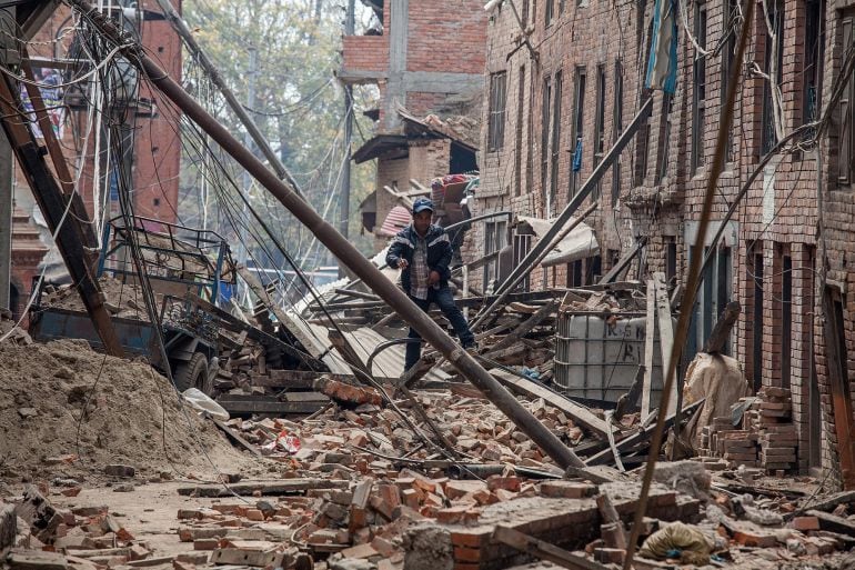 Un hombre camina entre los escobros de los edificios destruidos de la ciudad de Bhaktapur, en Nepal.