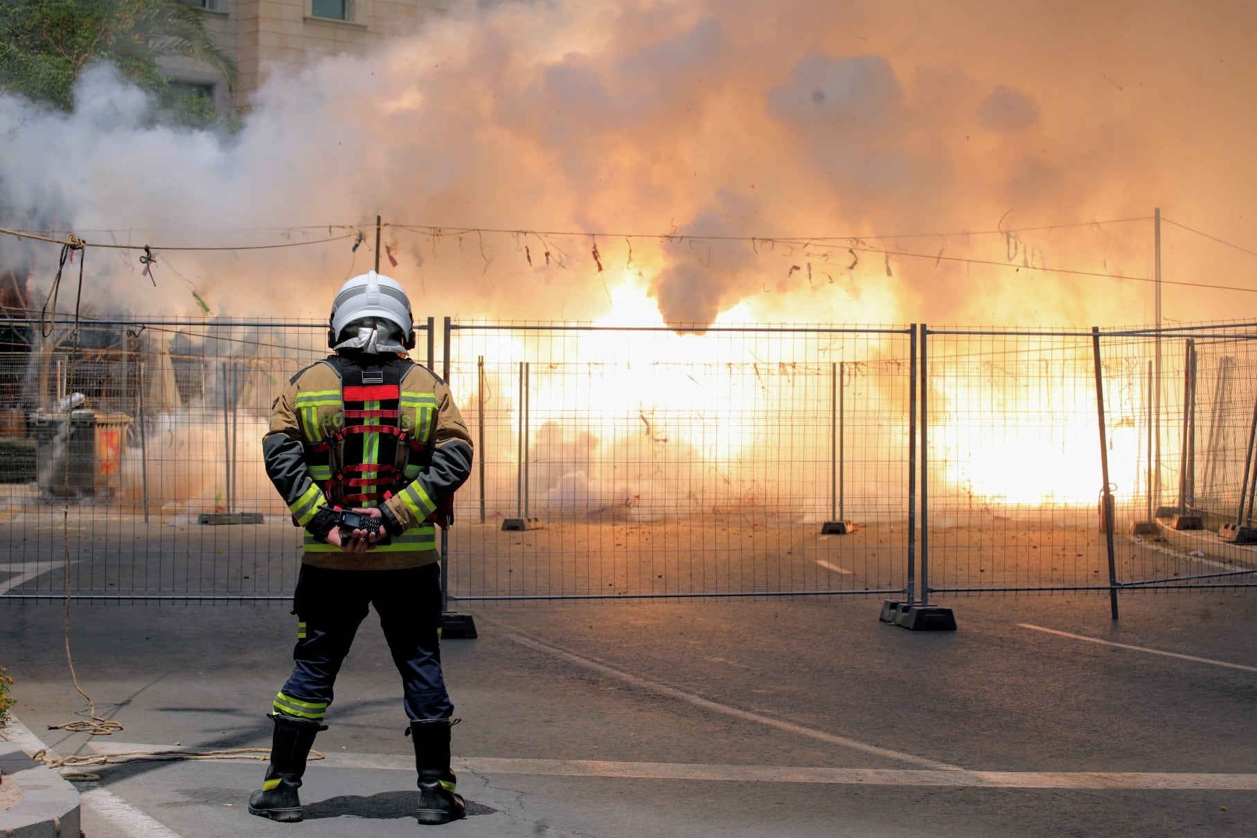 Un bombero de Alicante controla el perímetro de Luceros durante una mascletá lanzada en Hogueras