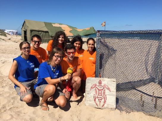 Grupo de voluntarios y miembros de Xaloc en el Campamento Tortuga de El Saler junto con un nido de tortuga boba