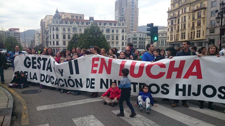 Las Asociaciones de Madres y Padres de los Colegios oventenses Gesta I y Gesta II cortando el tráfico ante la Junta General del Principado.